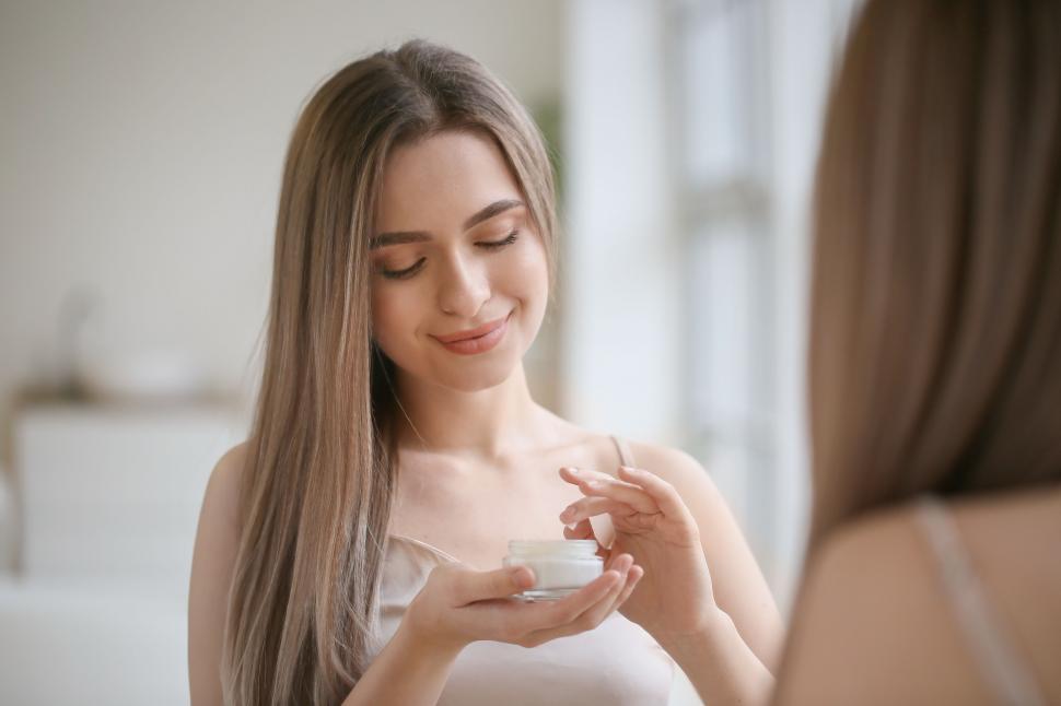 vrouw met potje creme in hand